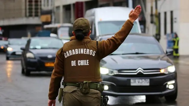 Carabinero dirigiendo el tránsito, visto desde atrás