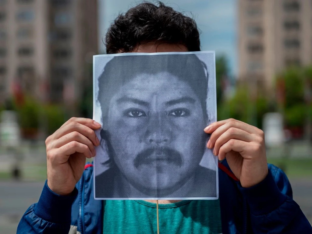 Persona sosteniendo un retrato en una manifestación